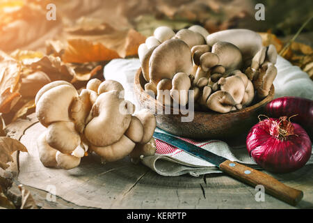 Raw mushrooms on the stump and autumn leaves. Autumn still-life. Selective focus. Autumn background. Stock Photo