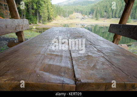 Wooden table by the lake in autumn Stock Photo