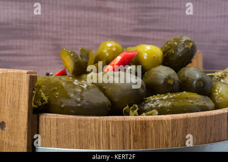 salted cucumbers with red pepper lie in a barrel Stock Photo