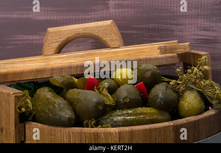 cucumbers with red pepper lie in a barrel under the lid Stock Photo