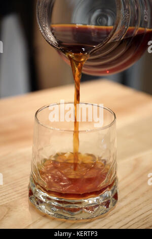 Barista pours a coffin into the glass cup serves a drink. Kemex Stock Photo