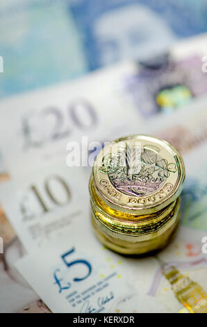 British currency - pile of new (2016) pound coins on £5 £10 and £20 notes Stock Photo