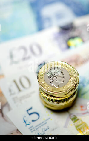 British currency - pile of new (2016) pound coins on £5 £10 and £20 notes Stock Photo