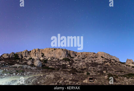 The cliffs at Mgiebah Bay in Malta, under a starry sky. Stock Photo