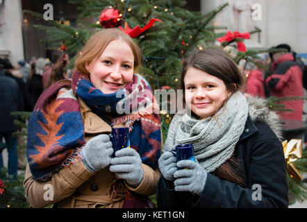 Two young women with mulled wine, Christkindlmarkt, Salzburg, Austria Stock Photo