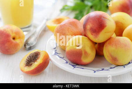 Still life with fresh ripe nectarines on white wooden table Stock Photo
