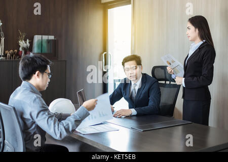 Asian businessmen and group using notebook for business partners discussing documents and ideas at meeting and business women smiling happy for workin Stock Photo