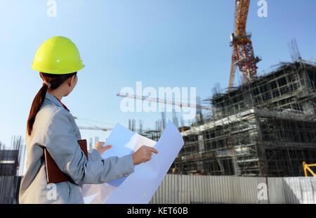 portrait women asia engineer working and holding blueprints at construction site Stock Photo