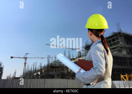 portrait women asia engineer working and holding blueprints at construction site Stock Photo