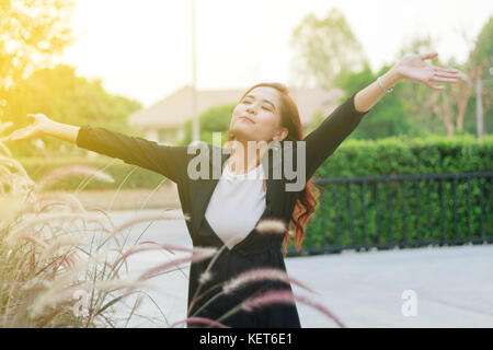 blurry of Successful business woman with arms up and Happy celebrating winning success woman at sunset or sunrise standing elated with arms raised up  Stock Photo