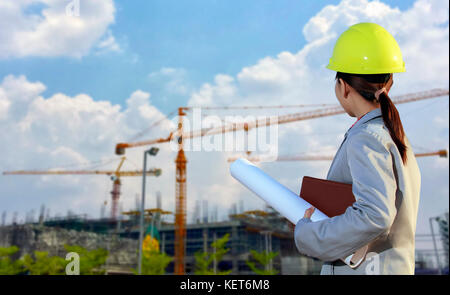 portrait women asia engineer working and holding blueprints at construction site Stock Photo
