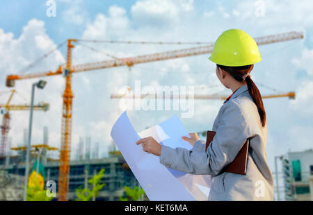 women asia engineer working and holding blueprints at construction site Stock Photo