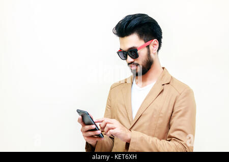 Asian business man handsome man with a mustache, smiling and laughing and using smart phone ,Blurry and soft focus Stock Photo