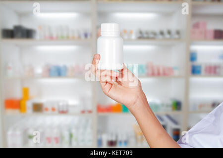 hand of doctor holding medicine bottle on medicine cabinet and store medicine and pharmacy drugstore Stock Photo