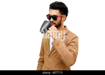 Portrait of a handsome asian young businessman drinking coffee. Isolated on white background. Stock Photo