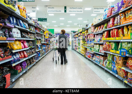 Shopping in a Morrisons supermarket -  shopper walking down an aisle in a Morrisons Supermarket. Stock Photo