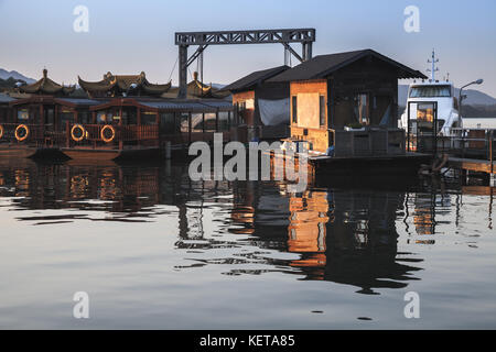 Hangzhou, China - December 5, 2014: Traditional Chinese wooden boats moored near floating pontoons on the West Lake, famous park in Hangzhou city Stock Photo