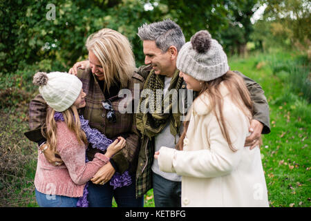 family of four with teenagers in park Stock Photo