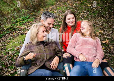 family of four with teenagers in park Stock Photo