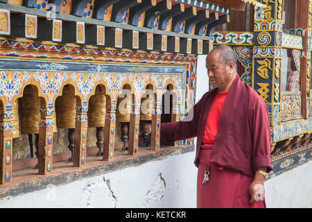 A buddhist monk beside the sacred bells in the monastery of Thimphu Wangdue Bhutan Asia Stock Photo