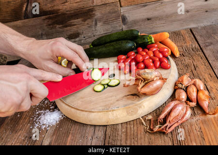 Chef cuts fresh vegetables essential ingredients of typical and healthy Italian cuisine Stock Photo