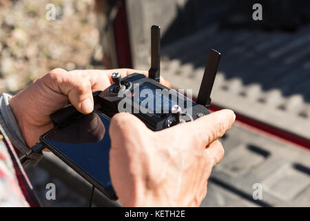 A male's hands operating a joystick of a Mavic Pro drone Stock Photo
