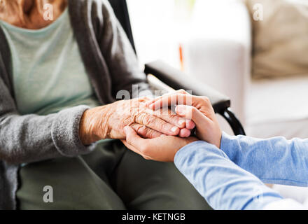 Unrecognizable health visitor and a senior woman during home vis Stock Photo