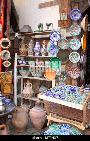 Traditional moroccan souvenirs - plates, tagines, mirrors, and pots made of clay, souk in Fes, Morocco, Africa Stock Photo
