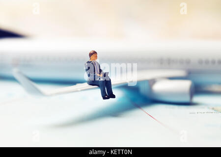 business travel concept - businessman sitting on a plane wing and working with laptop Stock Photo