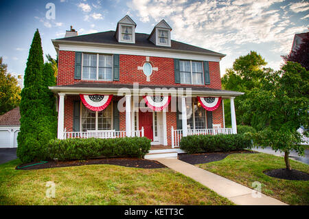 A colonial house in Medford, New Jersey with American Flag buntings on the porch. Stock Photo