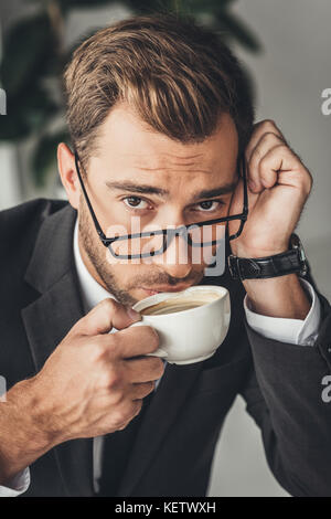 overworked businessman drinking coffee Stock Photo