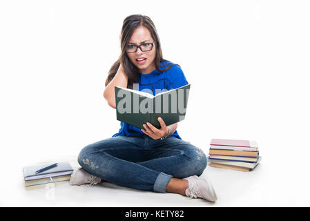 Beautiful student girl sitting looking scared on notebook isolated on white background with copypsace advertising area Stock Photo