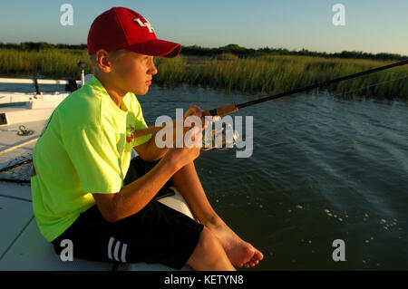 Young kids fishing for redfish or red drum on the bay near Port Aransas, Texas Stock Photo