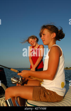 Young kids fishing for redfish or red drum on the bay near Port Aransas, Texas Stock Photo