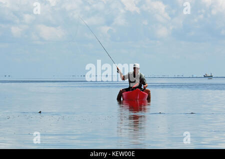 A fly fisherman fishing for tailing redfish or red drum from a kayak on the shallow flats near Port Aransas, Texas Stock Photo