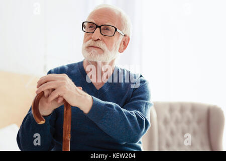 Serious grey-haired man being deep in thoughts Stock Photo