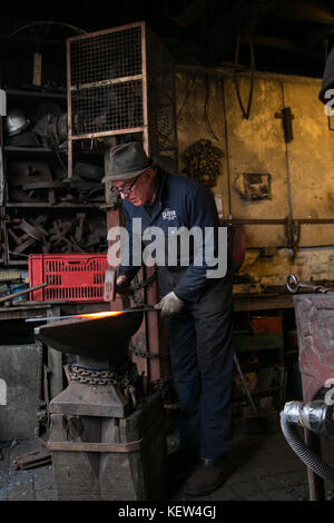 February 10, 2015 - London, United Kingdom - A blacksmith seen working in his workshop..A blacksmith is someone who creates artificial objects from raw iron or steel by forging them to make new creative products such as furniture, agricultural implements, gates, grilles, cooking utensils, railings, light fixtures, sculpture, tools, decorative and religious items, and weapons. Although, there are some more other carriers that are related such as wheelwrights, armors and furriers. The blacksmith has the general knowledge to create and repair many things which has been made with metal, such as th