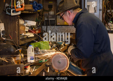 February 10, 2015 - London, United Kingdom - The blacksmith seen working on a metal..A blacksmith is someone who creates artificial objects from raw iron or steel by forging them to make new creative products such as furniture, agricultural implements, gates, grilles, cooking utensils, railings, light fixtures, sculpture, tools, decorative and religious items, and weapons. Although, there are some more other carriers that are related such as wheelwrights, armors and furriers. The blacksmith has the general knowledge to create and repair many things which has been made with metal, such as the m