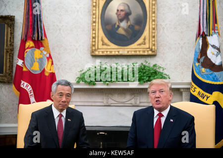 US President Donald Trump (R) welcomes Prime Minister Lee Hsien Loong (L) of Singapore to the Oval Office before a series of meetings between the two at the White House in Washington, DC, USA, 23 October 2017. The meeting comes less than two weeks before President Trump makes an extended trip to the Asia-Pacific region. Credit: Shawn Thew/Pool via CNP /MediaPunch Stock Photo
