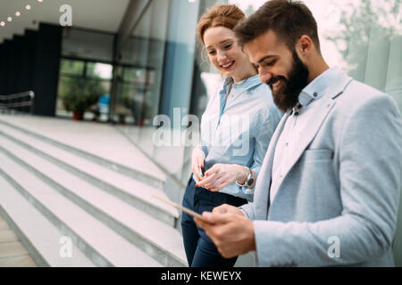 Business couple using digital tablet in front of office Stock Photo