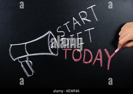 Close-up Of Person Hand Showing Start Diet Concept On Blackboard Stock Photo