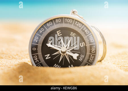 Close-up Of A Navigational Compass On Sandy Beach Stock Photo
