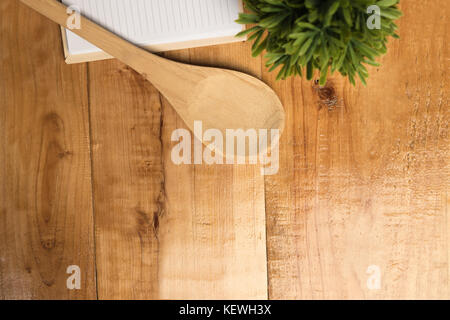 spoon over blank book and small tree top view on desk, copy space, kitchen object Stock Photo