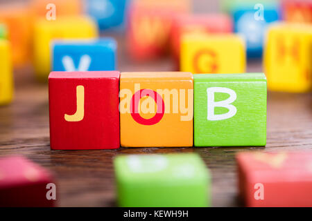 Close-up Of A Job Word On Colorful Blocks At Wooden Desk Stock Photo