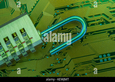 Close-up of small combination padlock on an an electronic circuit board. For cyber threat, cyber security, data breach, hacking, insecure payment etc. Stock Photo