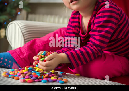 Adorable preschool girl playing with sweets Stock Photo