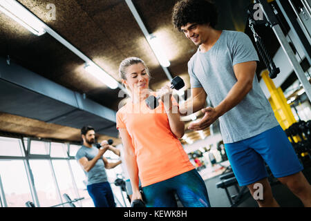 Young beautiful woman doing exercises with personal trainer Stock Photo