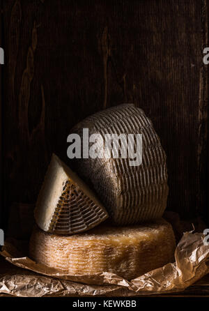 Wooden box with different types of home cheese. Composition in dark colors Stock Photo