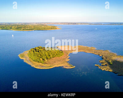 Small peninsula with pine trees in Mamerki, Mazury district lake, Poland