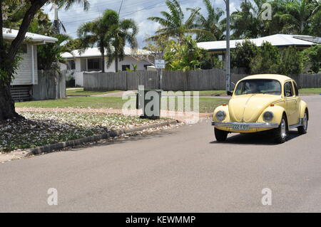 Faded yellow volkswagen beetle in a suburban street, Townsville, Queensland, Australia Stock Photo